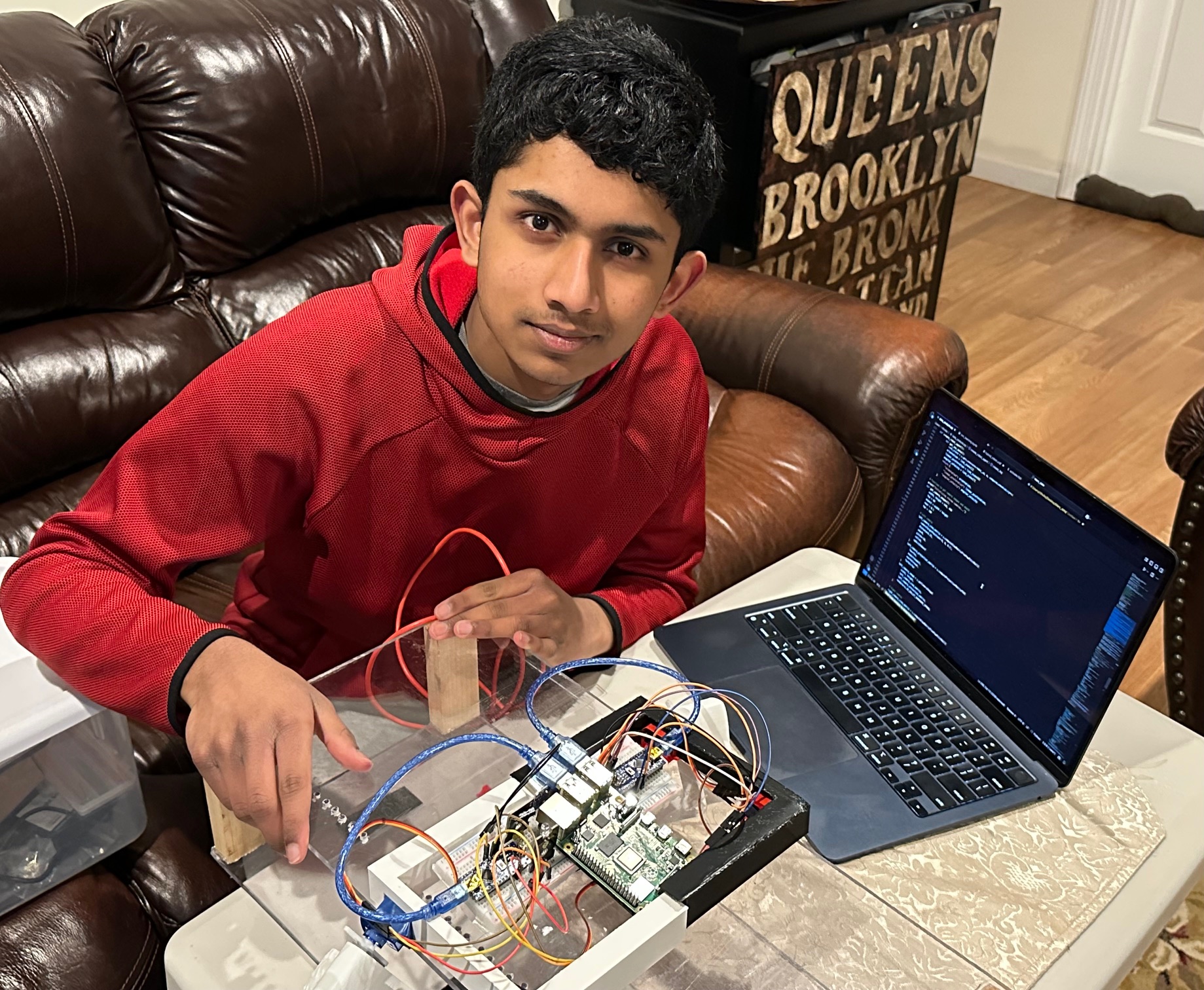 Rithvik Suren wiring a Raspberry Pi-based rover prototype at a workbench